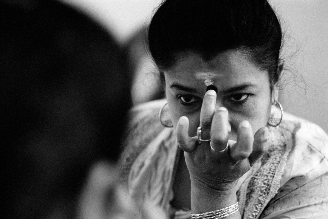 Eine tamilische Frau trägt ein Bindi auf die Stirn.